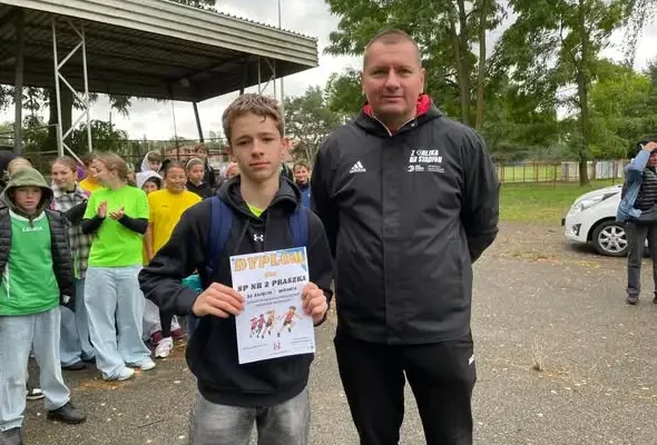 Sztafetowe biegi przełajowe w Praszce – uczniowie z medalami na stadionie