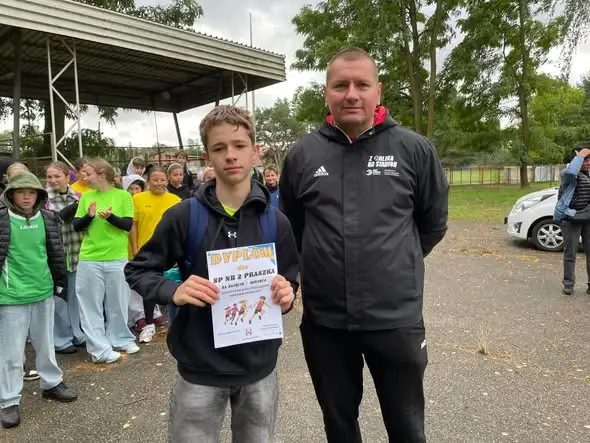 Sztafetowe biegi przełajowe w Praszce – uczniowie z medalami na stadionie